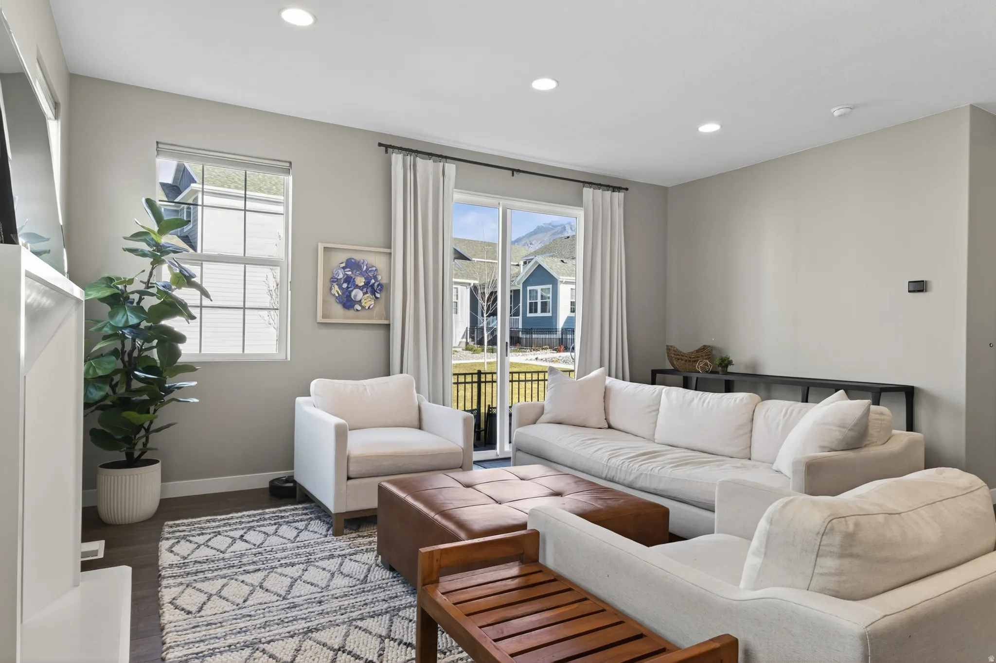 Recessed ceiling lighting, wood-finish flooring, sliding glass door, white window trim, and neutral wall tones