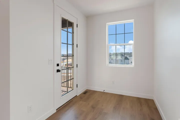 Wood-finish flooring, white walls, and a white trim