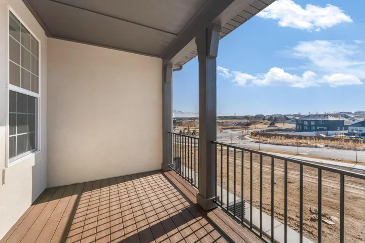 Covered balcony featuring wood-finish decking and dark-toned railing