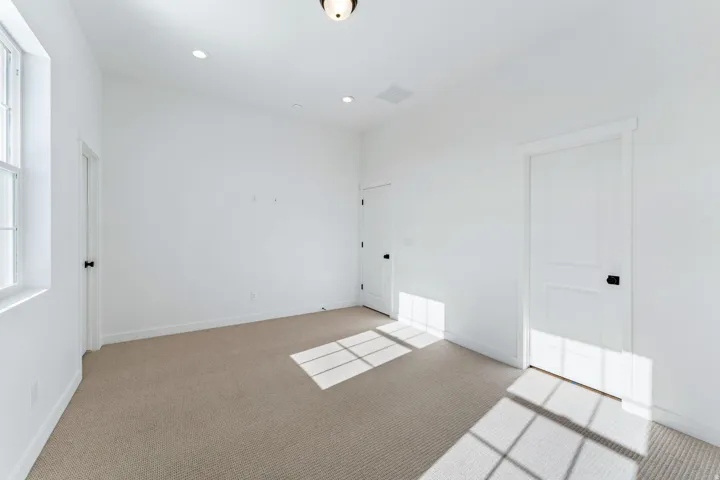 Light-toned carpeting, white walls, and recessed lighting