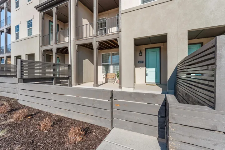 Stucco exterior with a turquoise entry door, complemented by a covered porch