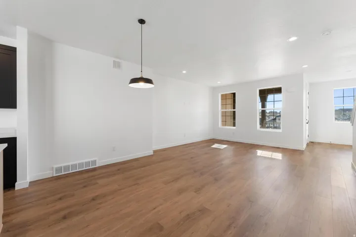 Wood-finish flooring throughout, complemented by recessed ceiling lighting and a modern pendant fixture