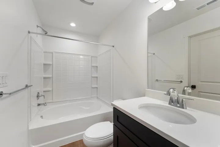 White single vanity with a solid surface countertop and chrome faucet