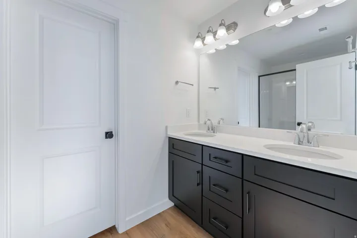 Dual vanity with dark wood-finish cabinetry, white countertops, and undermount sinks