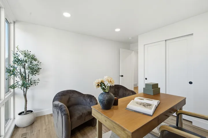Recessed lighting, wood-finish flooring, white walls, built-in sliding closet doors, and large windows