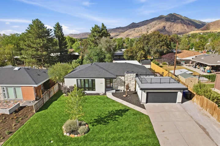 Contemporary exterior with a flat roof, stone chimney, and a landscaped front yard
