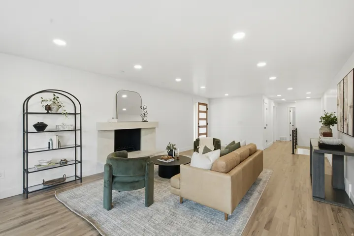 Living area featuring wood-finish flooring, recessed lighting, and a stone-clad fireplace