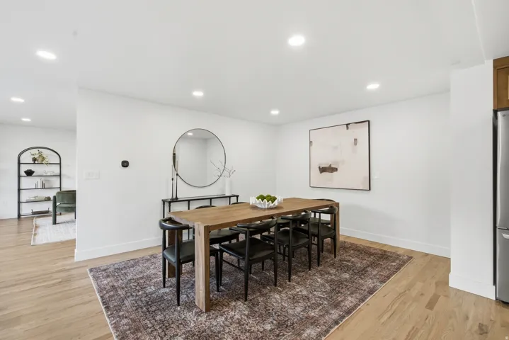 Recessed lighting, wood-finish flooring, and white baseboards