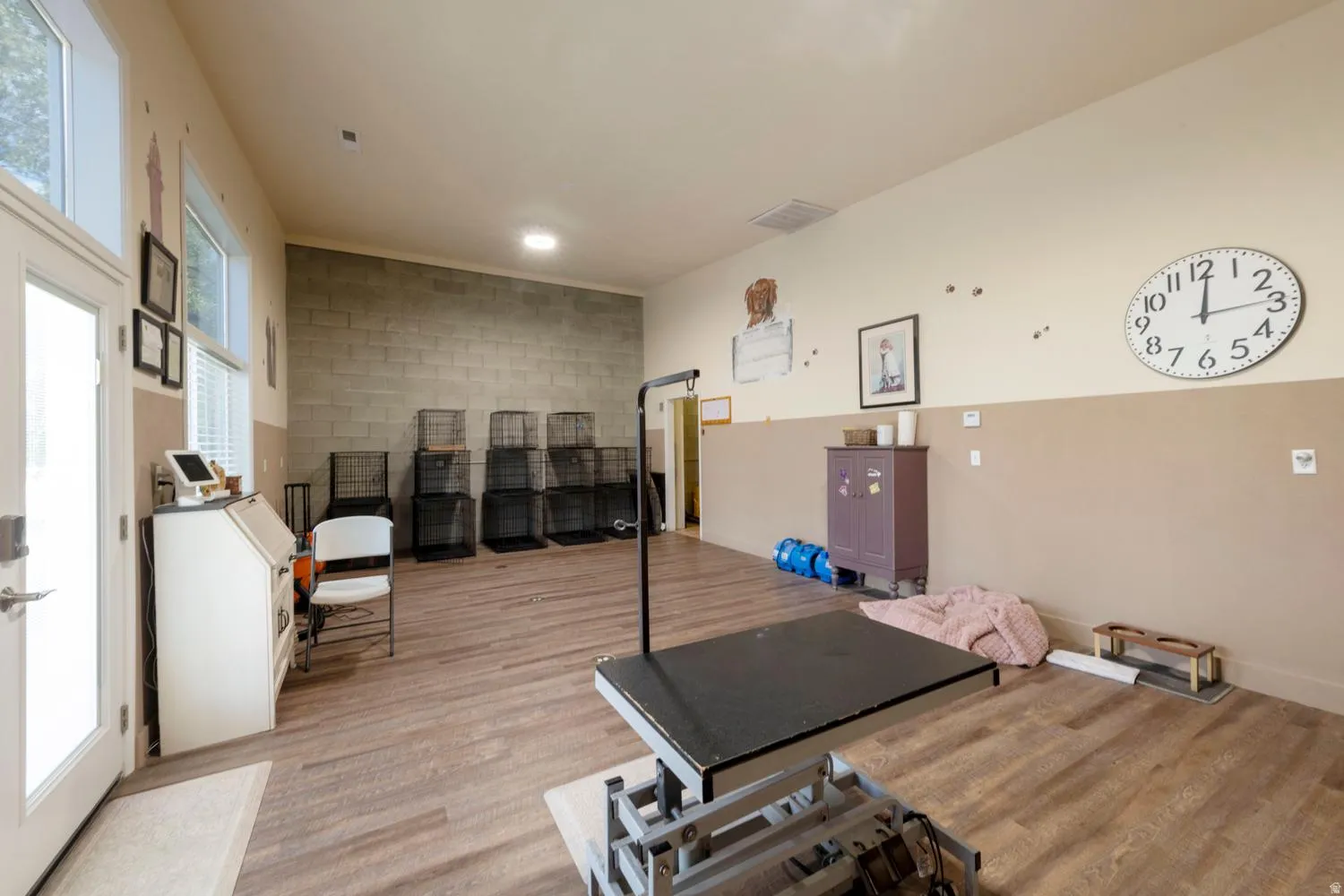 Spacious room featuring wood-finish flooring, a wall of glass block, and a two-tone wall treatment