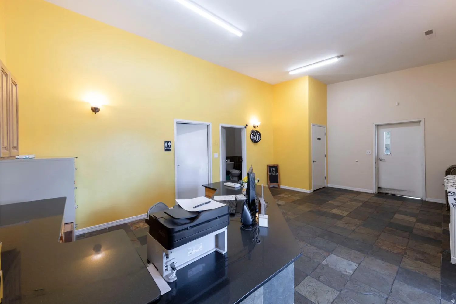 Spacious area with mixed-tone tile flooring, high ceilings, and recessed lighting