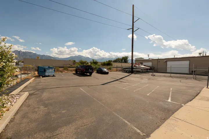 Paved parking area with marked spaces and chain-link fencing