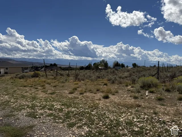 Expansive undeveloped land featuring natural terrain and distant mountain backdrop
