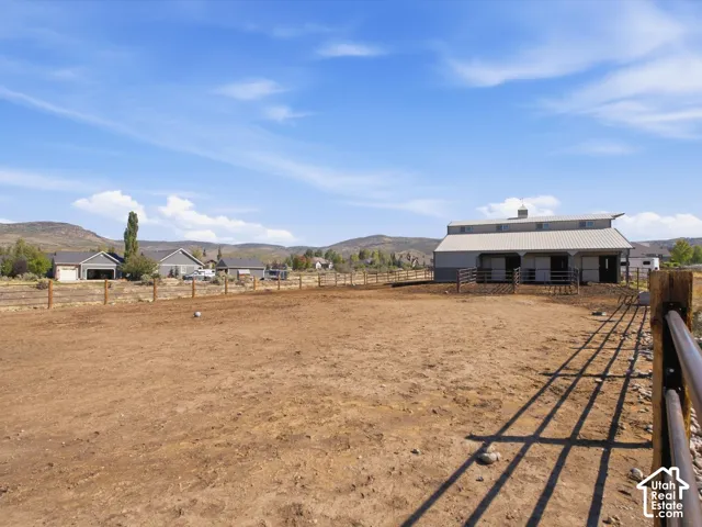 Metal-sided barn featuring an overhang and multiple stalls