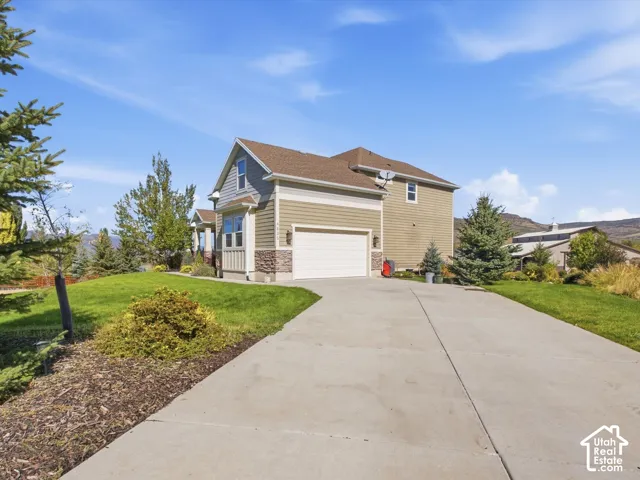 Two-story exterior with horizontal siding, stone accents, and an attached garage