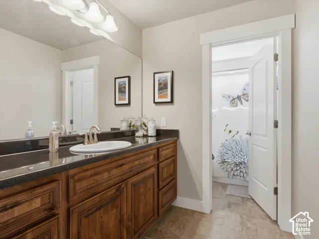 Double vanity with integrated sinks, dark wood-finish cabinetry, and a full-width mirror