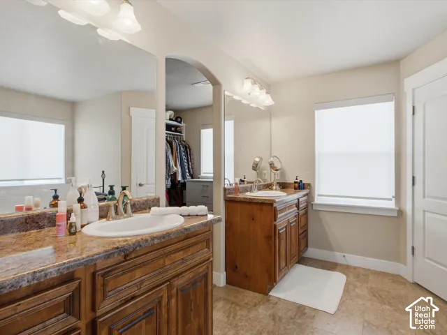 Dual wood-finish vanities with integrated sinks and stone-look countertops