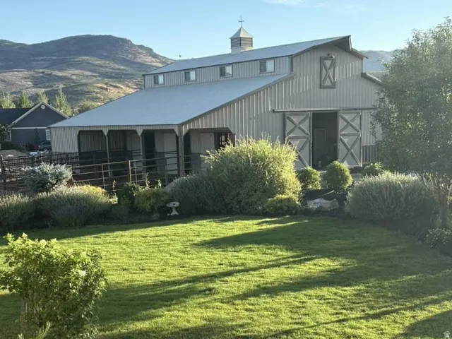 Expansive barn with a metal roof, cupola, and sliding barn doors