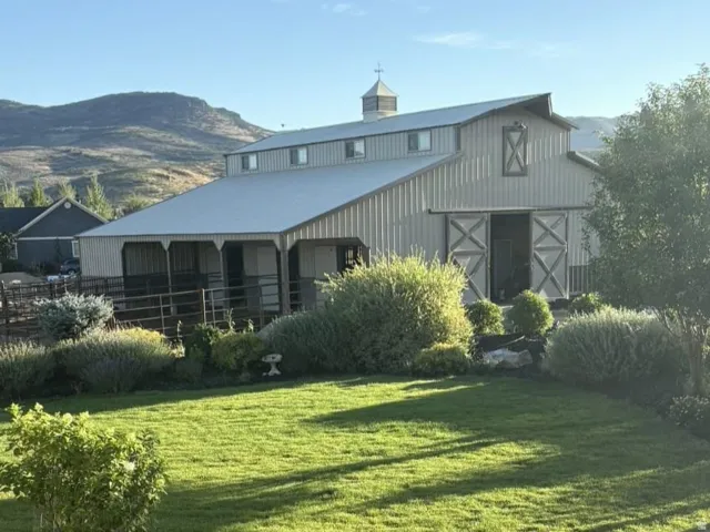 Expansive barn with a metal roof, cupola, and sliding barn doors
