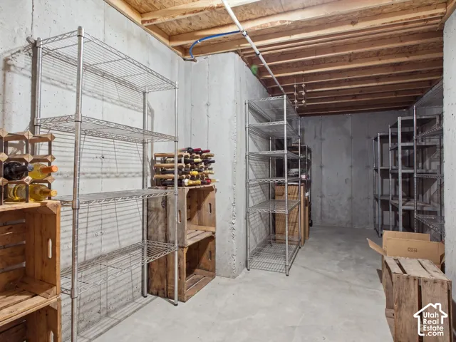 Unfinished basement space featuring exposed concrete walls, concrete flooring, and exposed ceiling joists
