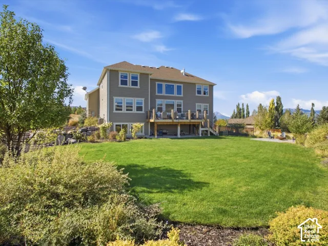 Rear exterior with an expansive lawn, multi-level deck, and walk-out lower level
