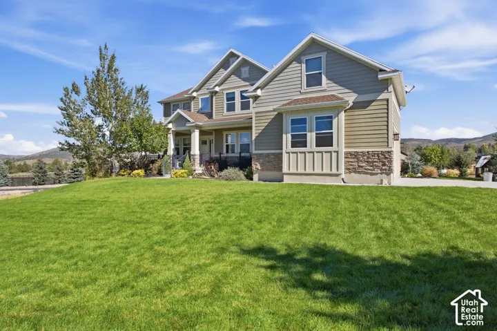 Two-story residence featuring siding and stone-veneer exterior, bay window, and gabled rooflines