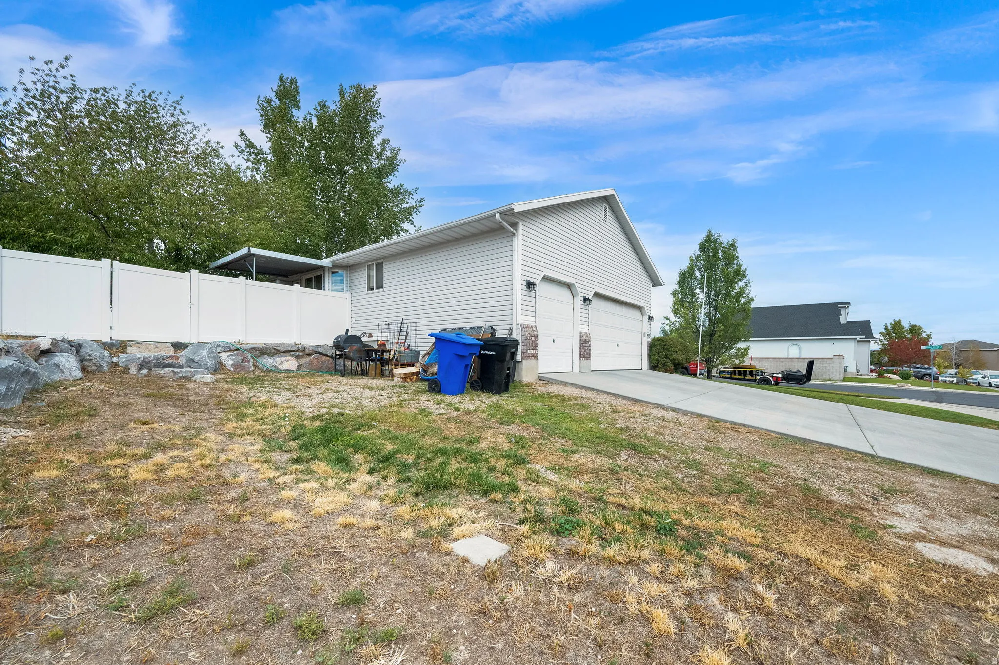 Two-car garage with white doors, light-colored siding, and a concrete driveway