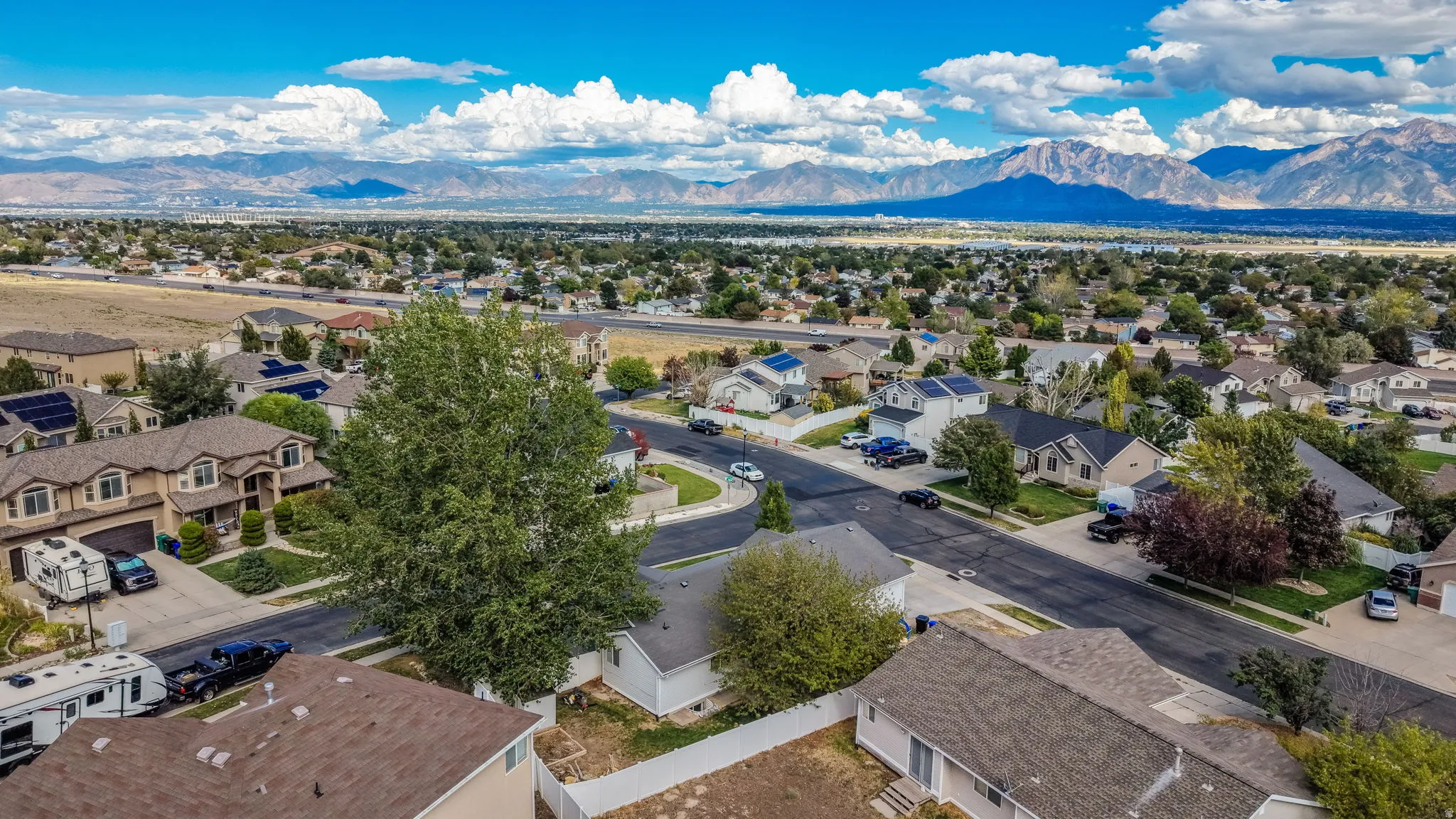 Expansive neighborhood setting with established homes, mature landscaping, and mountain scenery