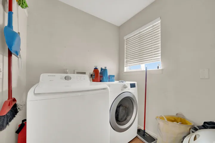 Dedicated laundry space with a window and wood-finish flooring