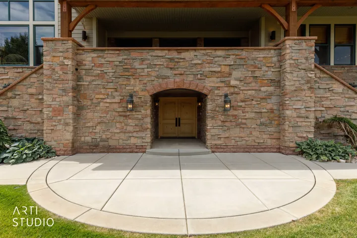 Stone facade with arched entryway and double wood doors