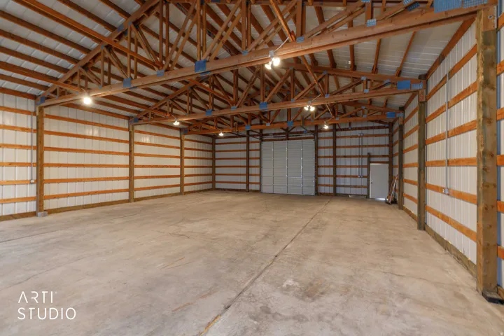 Expansive concrete flooring with exposed wood beam ceiling and industrial lighting