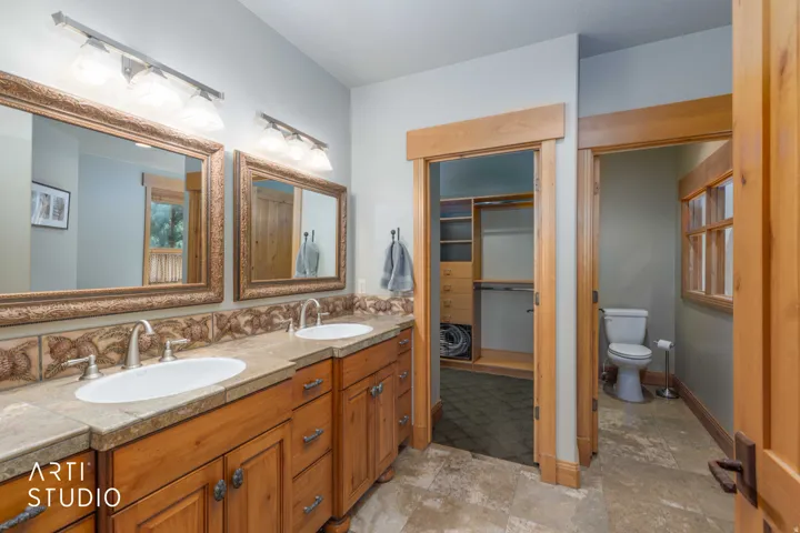 Master bath with dual vanity, undermount sinks, alder wood cabinetry with custom moldings and backsplash.