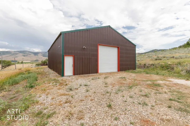 Metal-sided structure featuring a green roofline and red trim