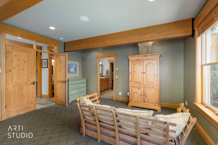 Master bdrm. Wood french doors, Sitting area to watch TV. Entrance to bath. Exposed wood beams, recessed lighting,