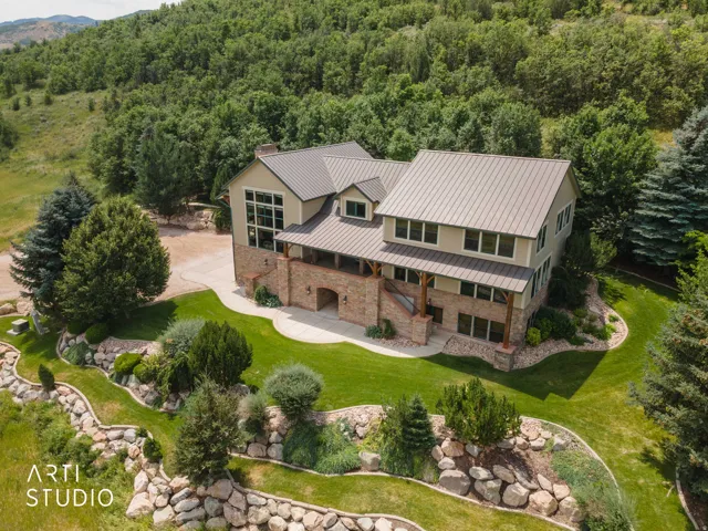 Multi-level residence with a metal roof and stone accents