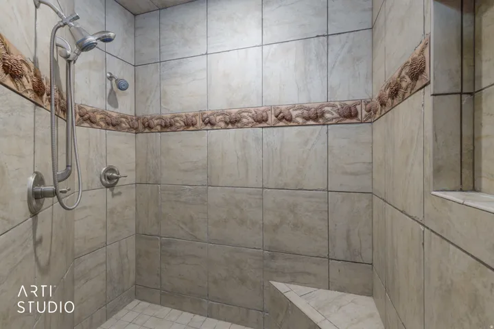 Master bath walk-in shower. Tiled shower enclosure featuring a built-in bench, recessed niche, and custom tile accents.
