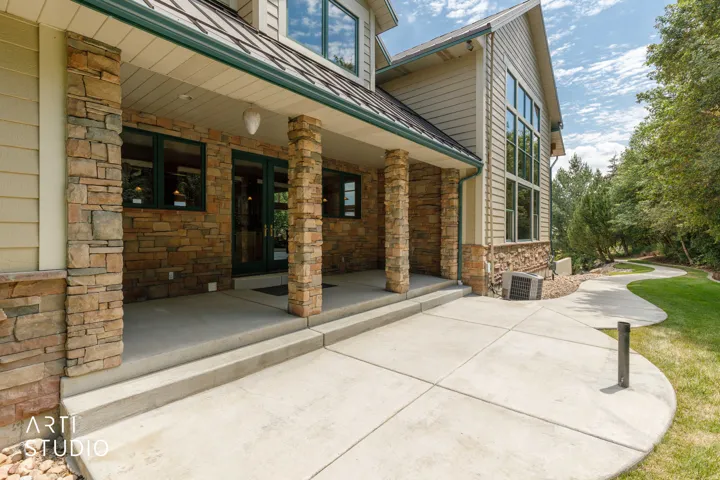 Backyard and covered porch. Well maintained landscaping.