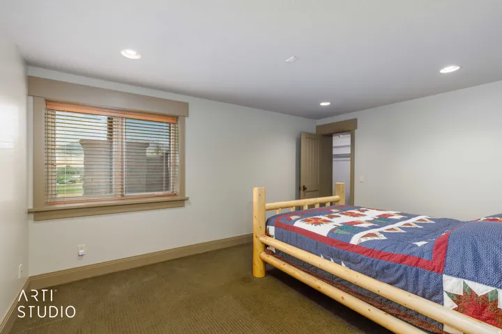 Recessed lighting, window with blinds, wood-trimmed window and door casing.