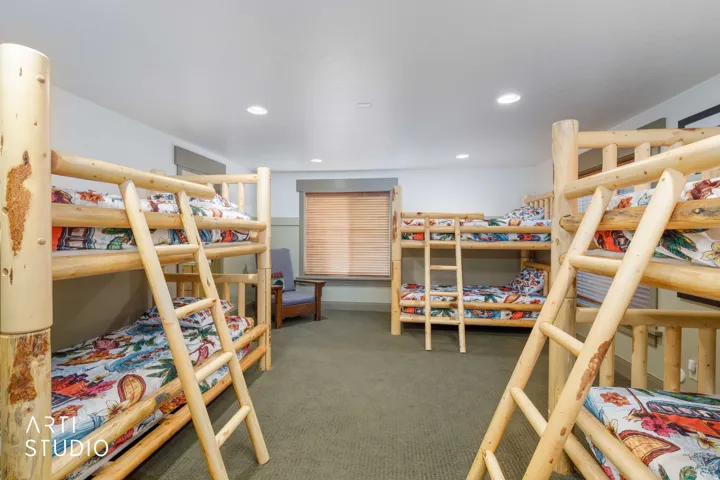 Boys large bunk room featuring multiple lodgepole pine bunk beds, recessed lighting, and window blinds.