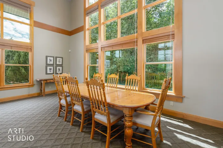 Expansive windows with custom wood moldings, exposed beams, neutral wall tones.