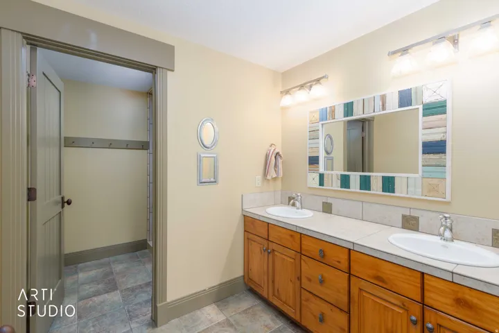 Girls bunkhouse bathroom.  Dual vanity with integrated sinks, view to large walk-in shower.