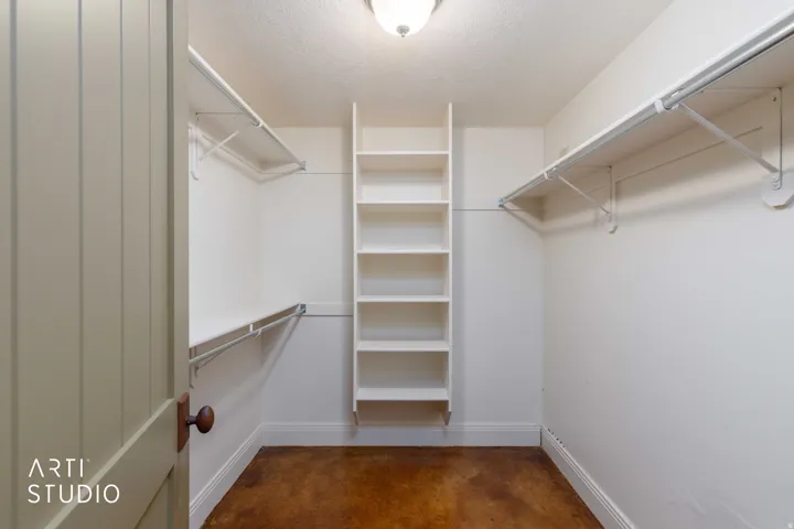Spacious walk-in coat/storage closet with built-in shelving.