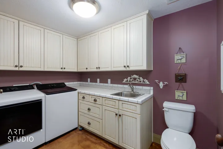 Half bath and laundry. Built-in cabinetry with beadboard paneling, integrated sink.