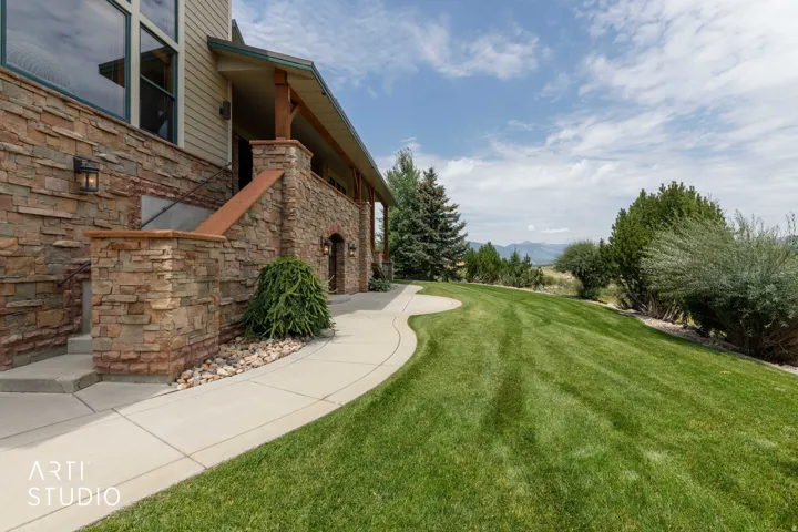 Stone veneer exterior with wood siding accents. Well maintained yard.