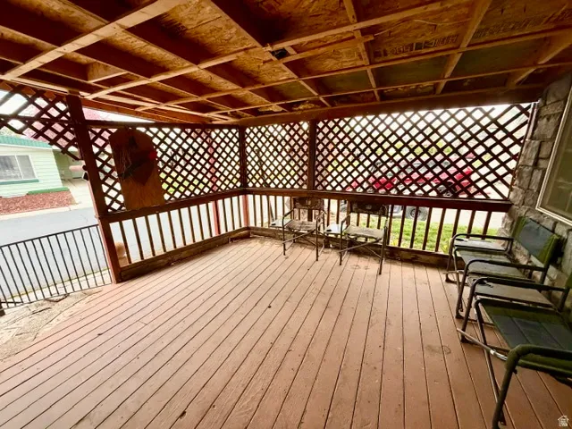 Covered wood-finish porch with latticework and a stone-clad exterior wall
