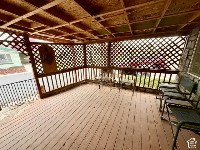 Covered wood-finish porch with latticework and a stone-clad exterior wall