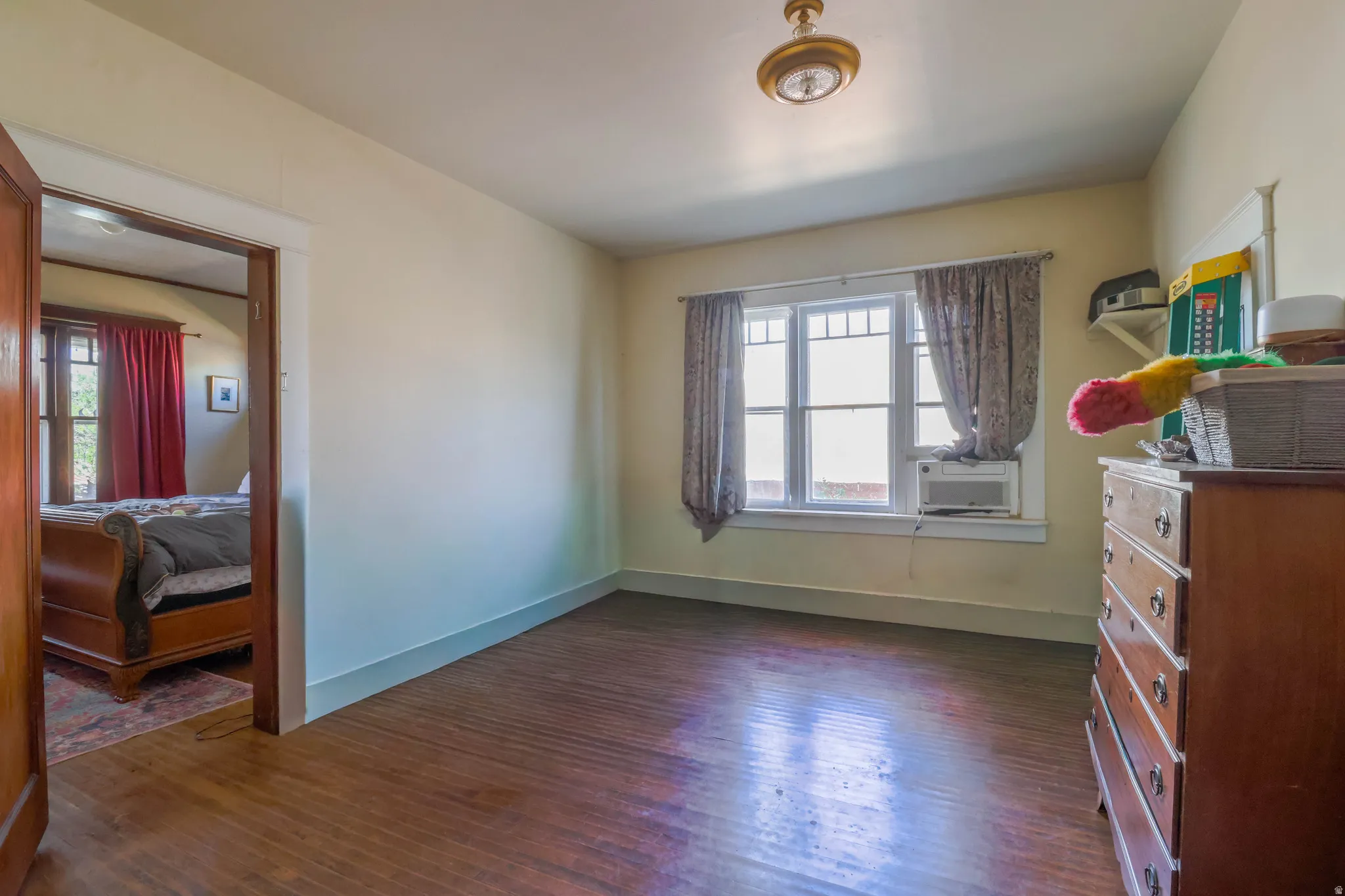 Hardwood flooring, multi-pane window, and a ceiling-mounted light fixture