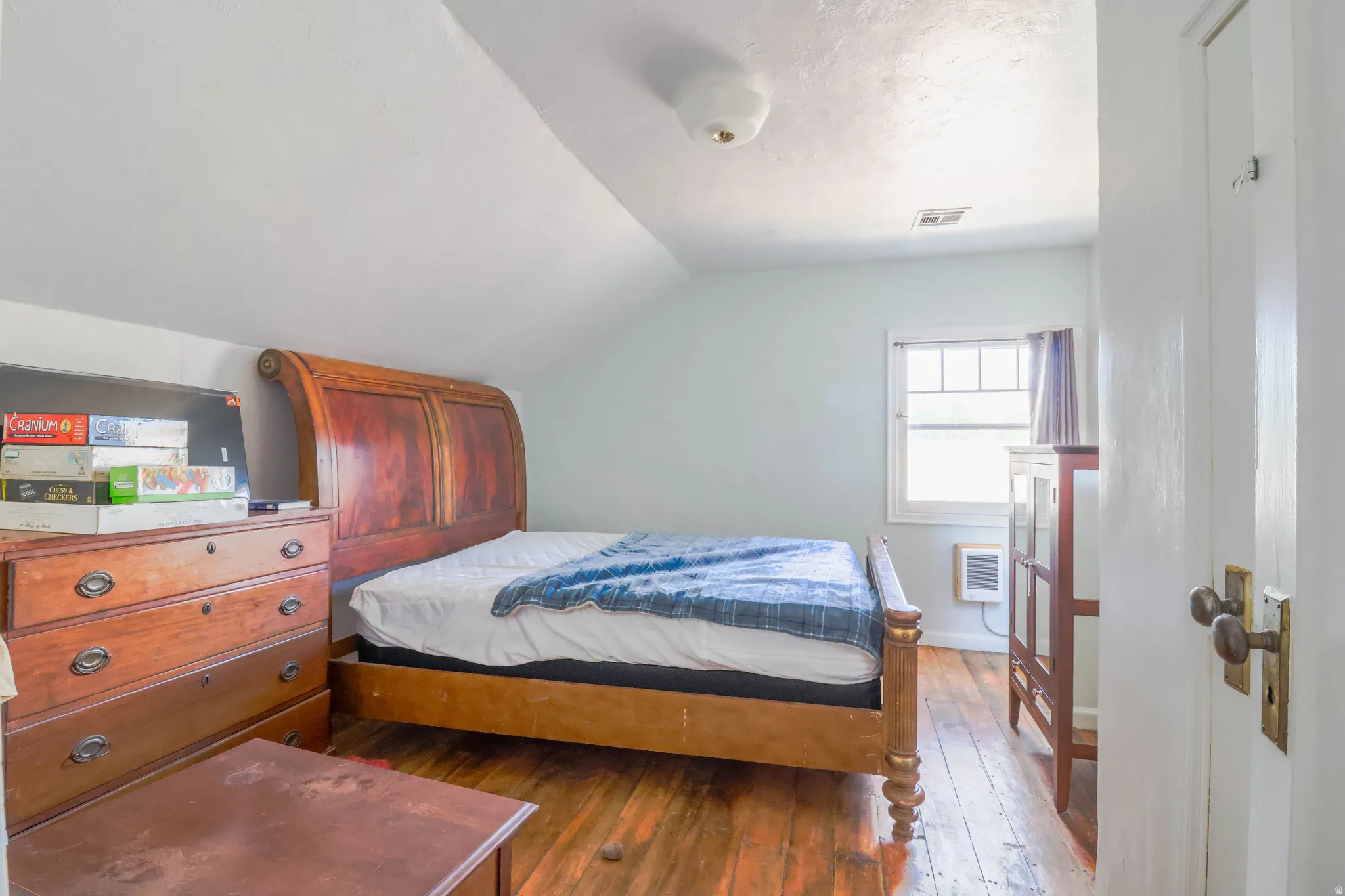 Hardwood flooring, painted walls, and a window with natural light