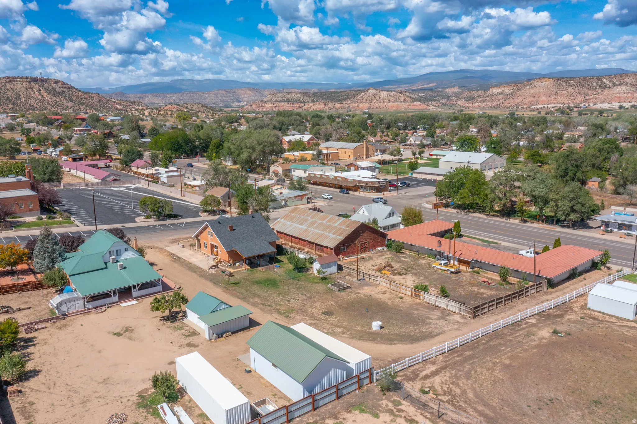 Expansive property featuring multiple structures including residences, outbuildings, and a large open lot