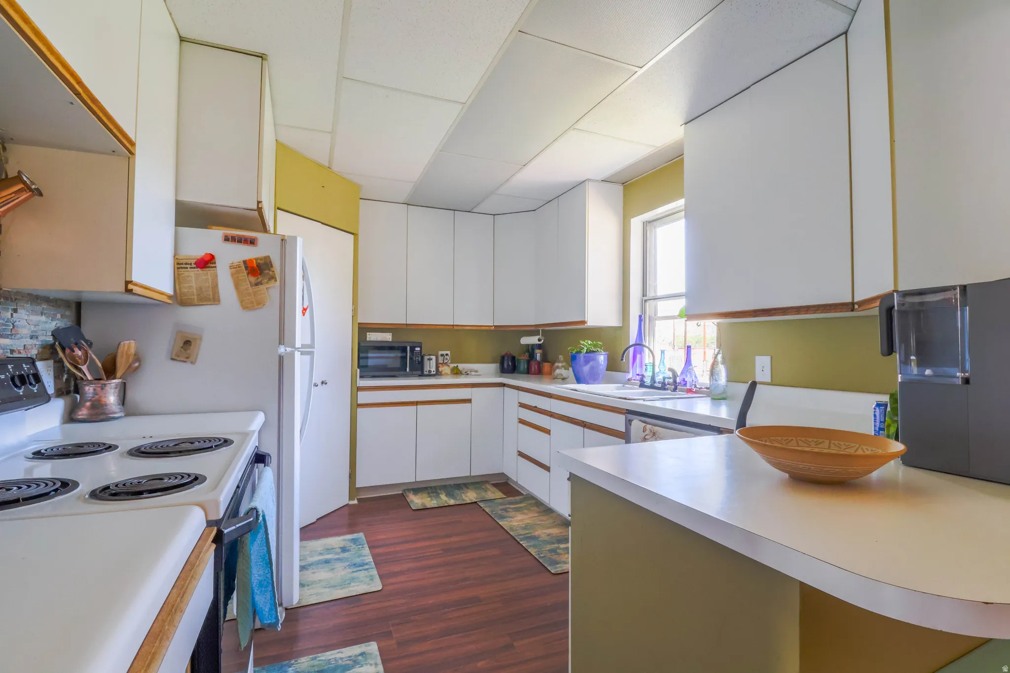 White cabinetry with wood trim, white countertops, built-in sink, and wood-finish flooring