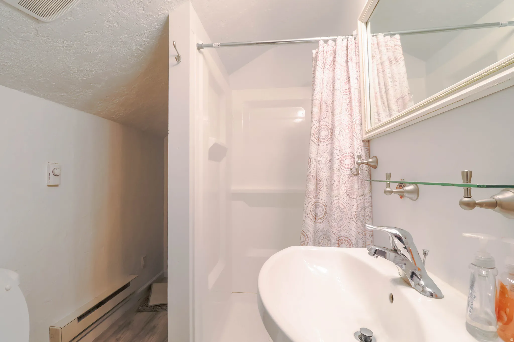 White vanity with an integrated basin, chrome faucet, and a wall-mounted mirror